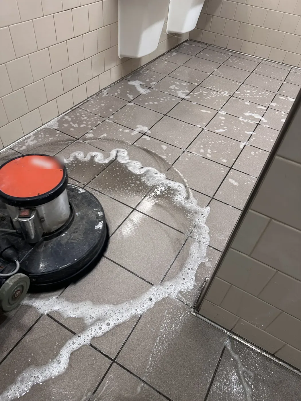 Deep scrubbing commercial restroom tile floor with a rotary floor machine